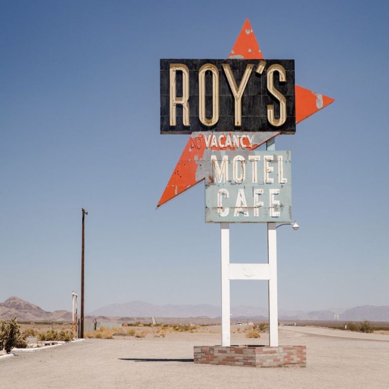 An inviting and well-lit motel exterior at dusk with a neon 'Vacancy' sign, symbolizing the importance of visibility and branding in effective motel marketing strategies.