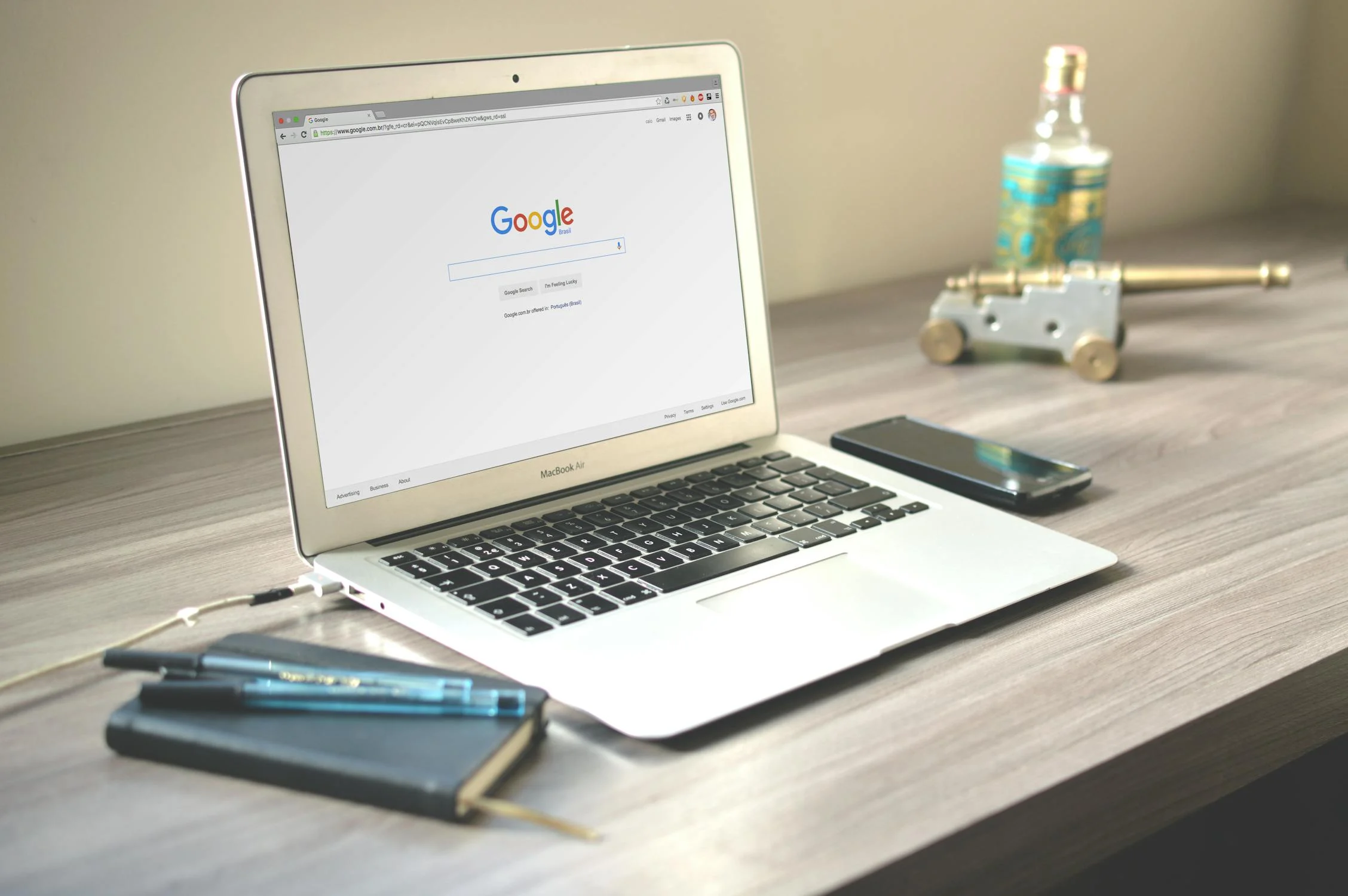 a notepad, phone and laptop on a bench with the Google search bar open used on a blog about hotel SEO
