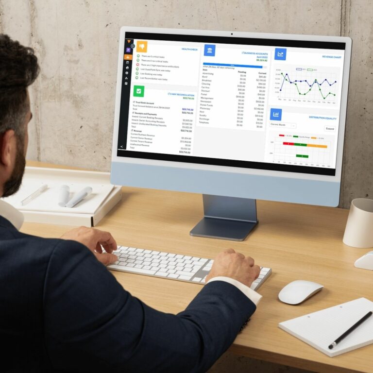 man working on a desktop computer showing GuestPoint PMS integrated trust account management used on a blog about trust accounting in property management