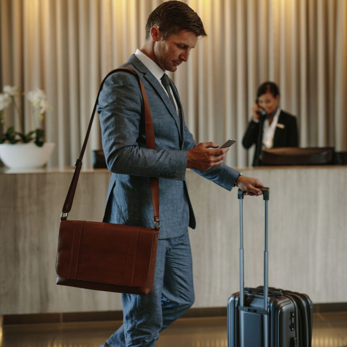 male business traveller with suitcase and laptop bag in the lobby of a hotel used on a blog about the global distribution system (GDS)