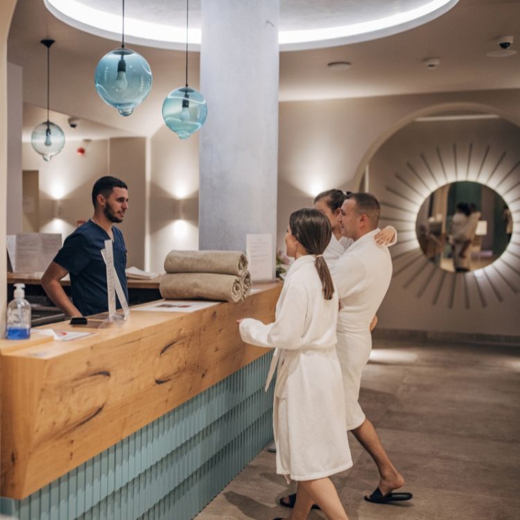 family in robes at a hotel spa reception area used on a blog about upselling hotel services to increase ancillary revenue
