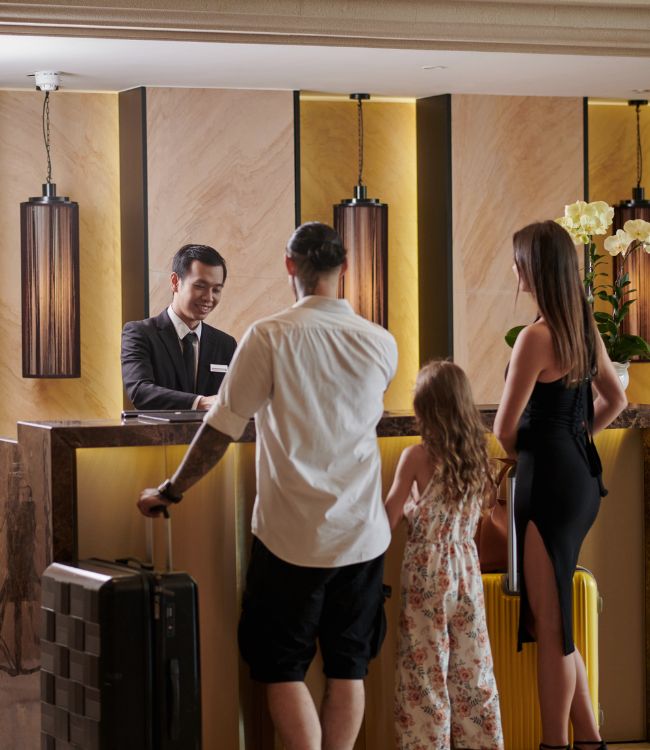couple with a child at a hotel reception used on a blog about property management automation