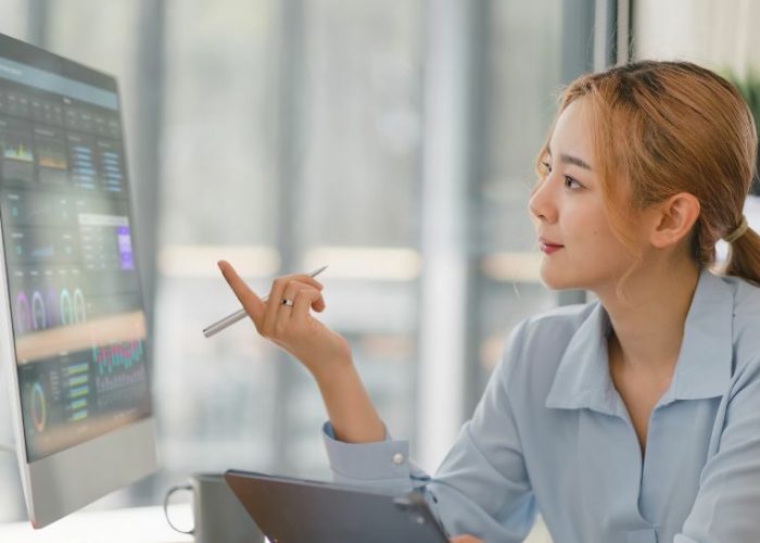 revenue management motels a woman at a desk pointing at a screen used on a page about property management consultants and property management training
